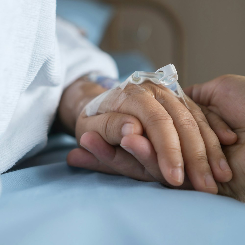 Patient holding hand of loved one